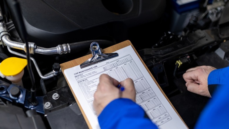 a mechanic checking maintenance logs