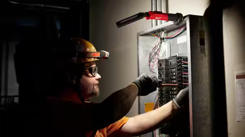 An electrician working with a Milwaukee light