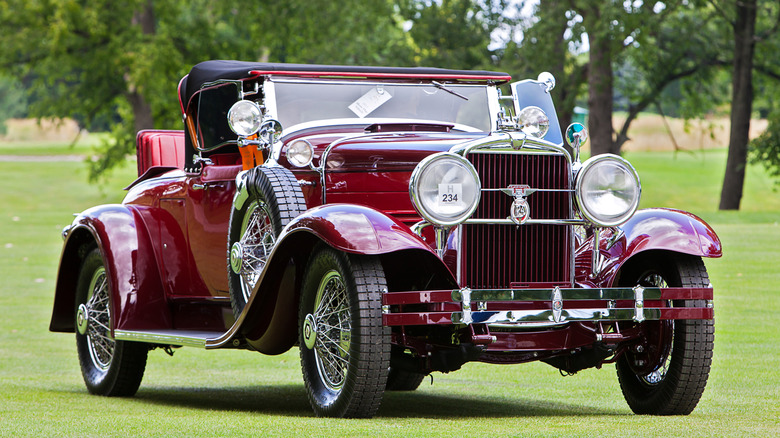 A burgundy 1929 Stutz Blackhawk Roadster parked on grass at a Concours D'Elegance event in Michigan.