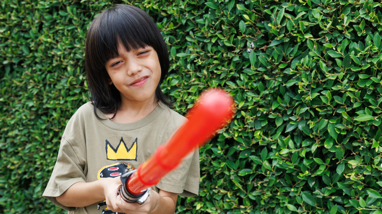 Young boy holding lightsaber