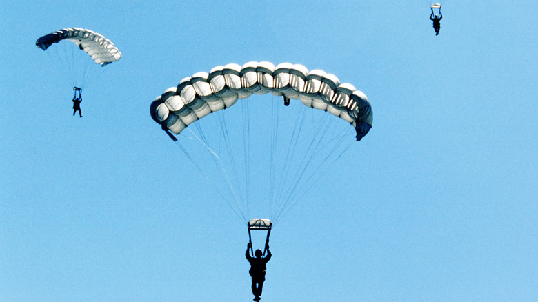 Three men with parachutes