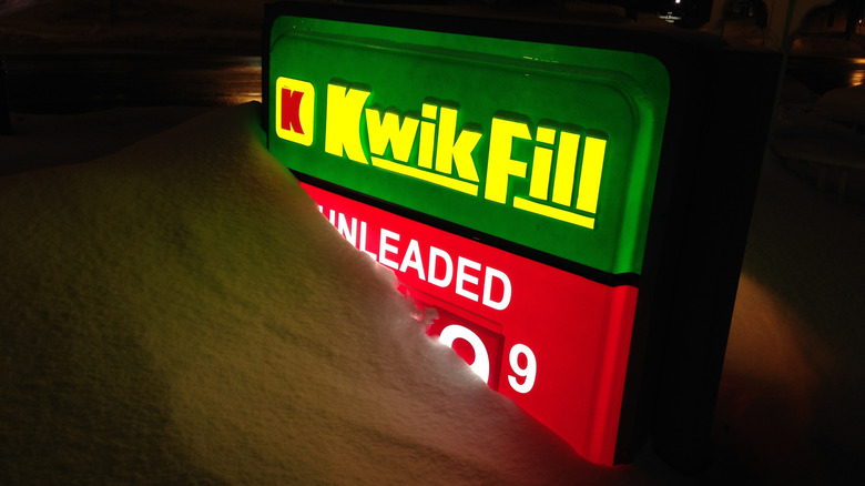 Lighted Kwik Fill gas station sign partially buried in snow