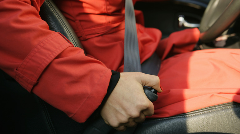 Close-up of right hand of man in winter gear pulling parking brake lever