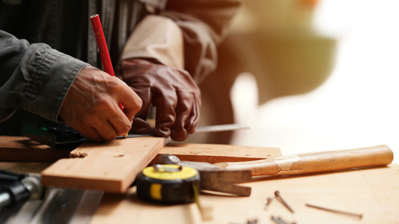 a woodworker marking a board