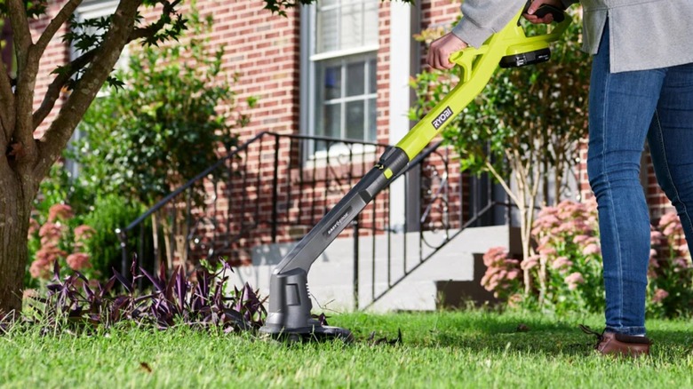 trimming grass with Ryobi string trimmer
