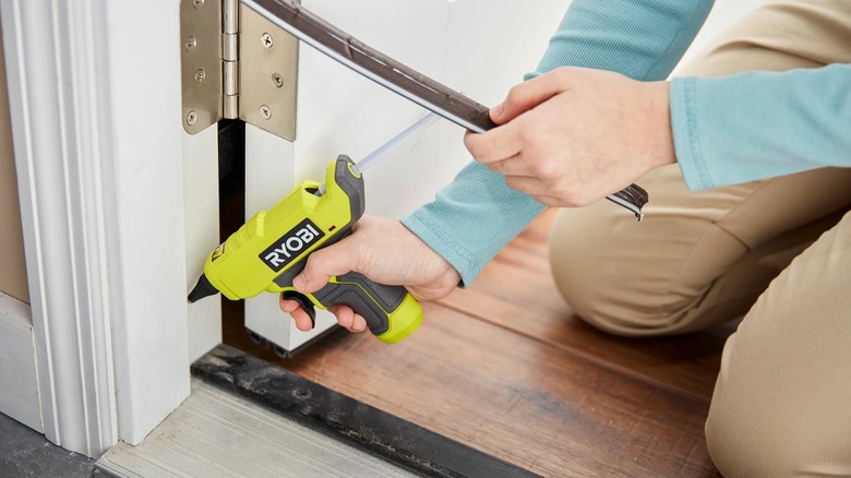gluing material into door jamb with Ryobi glue gun