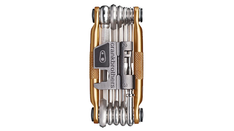 Gold and silver multi-tool with all the tools locked into place with a white background