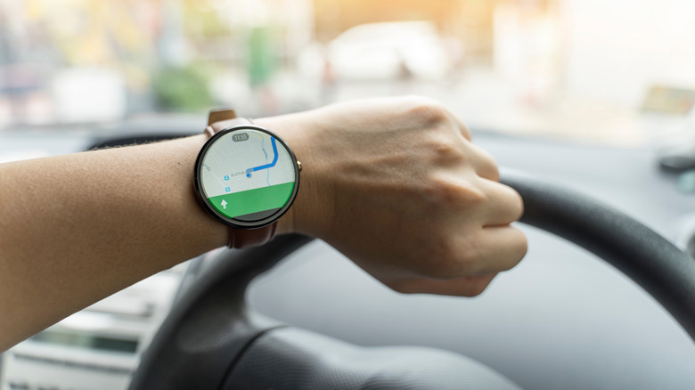Close up of man watching smartwatch and using application Google Maps to destination. navigation service by Google company.