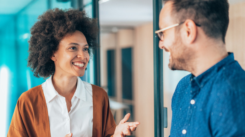 Two young business persons talking in the office.