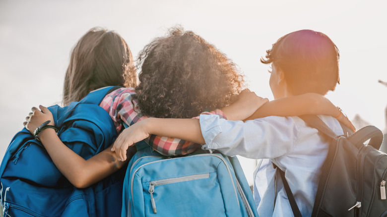 Behind view of group of kids wearing backpacks