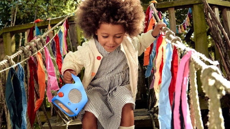 Young child holding a portable speaker