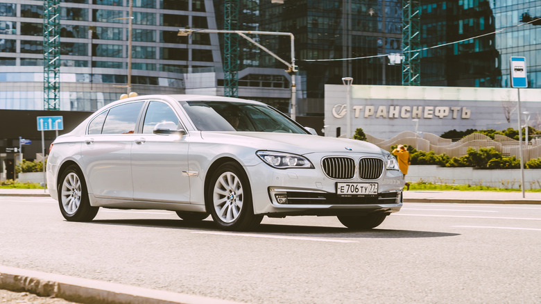 A BMW F02 chassis 740i on the road at speed on a sunny morning, finished in gunmetal grey