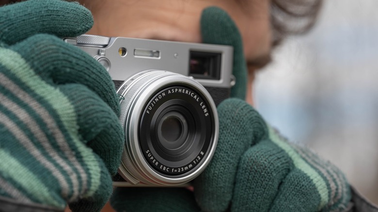 Photographer wearing gloves while taking photos with the Fujifilm X100VI.