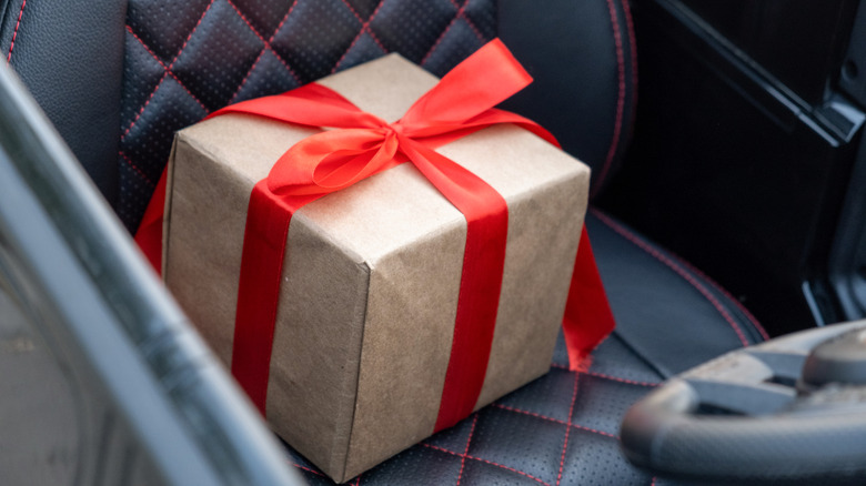 Gift wrapped in a red bow on a black car seat