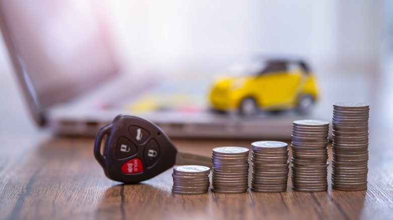 Stack of coins next to a pair of car keys
