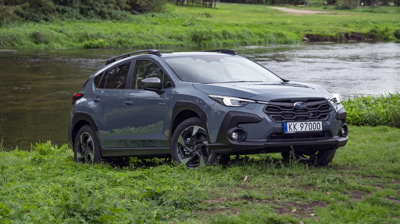 Blue Subaru Outback near a river