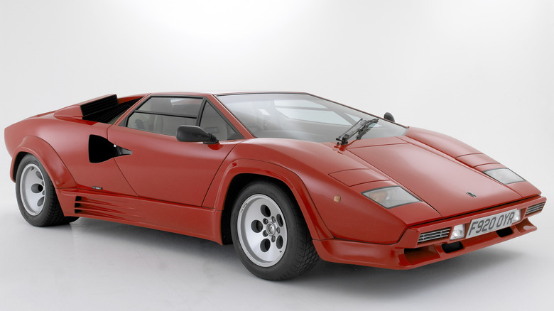 A red Lamborghini Countach on display on a white background in a museum