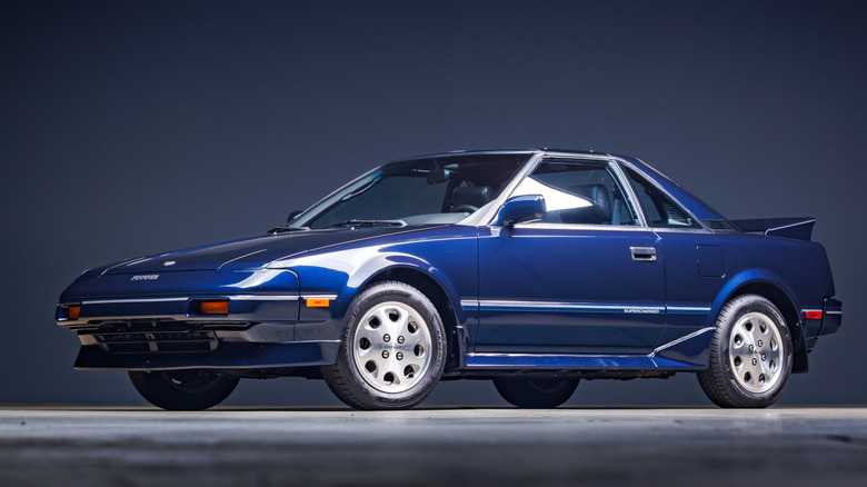 Blue Toyota MR2 on display with a dark studio background
