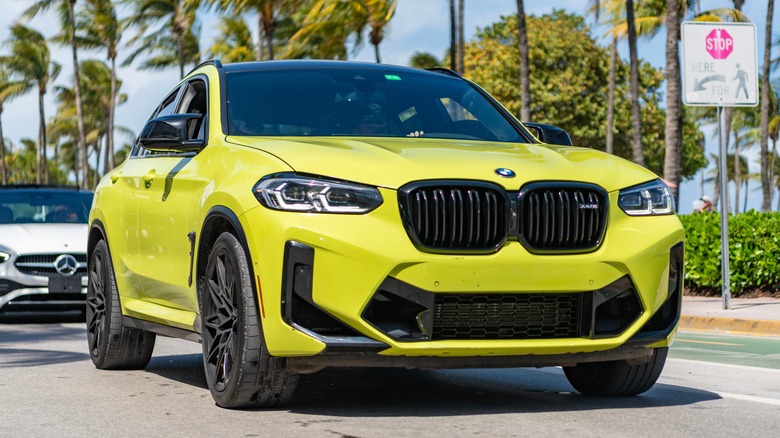 A yellow BMW x4 driving