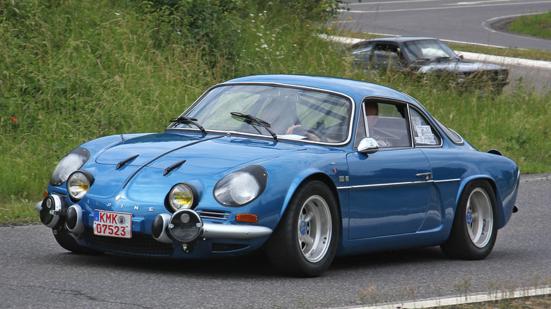 Blue Renault Alpine coupe seen from front left in a vintage race