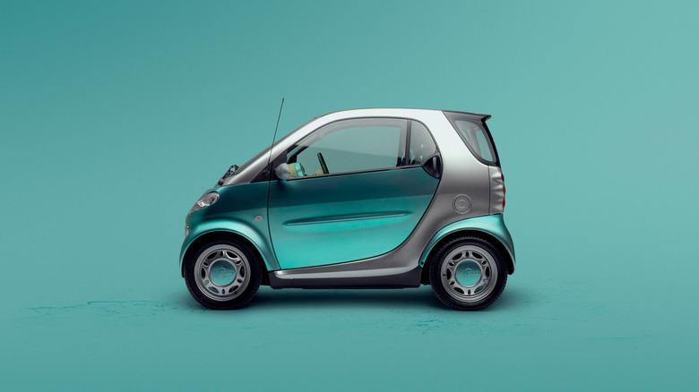 Green 2002 Smart ForTwo seen from left parked against a green studio background