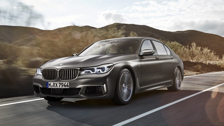 A black BMW 7 Series driving down a road
