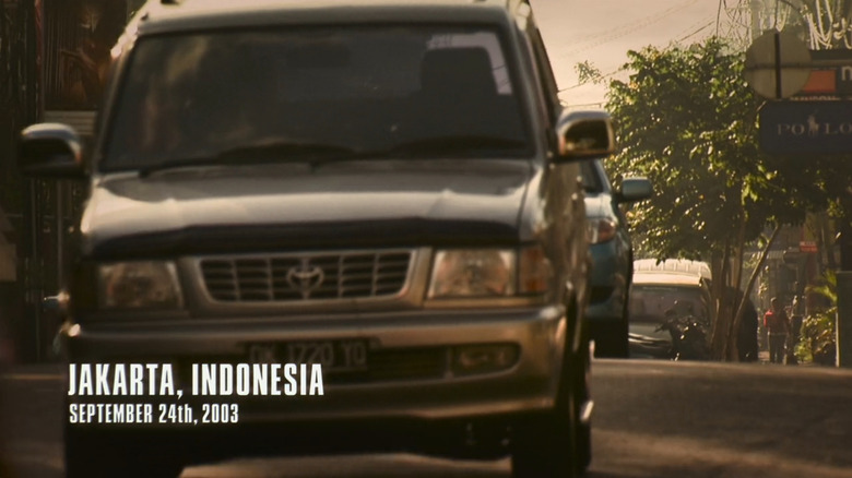 A Toyota Kijang navigates through busy Jakarta streets in a flashback scene from "The Last of Us," dated September 24th, 2003.