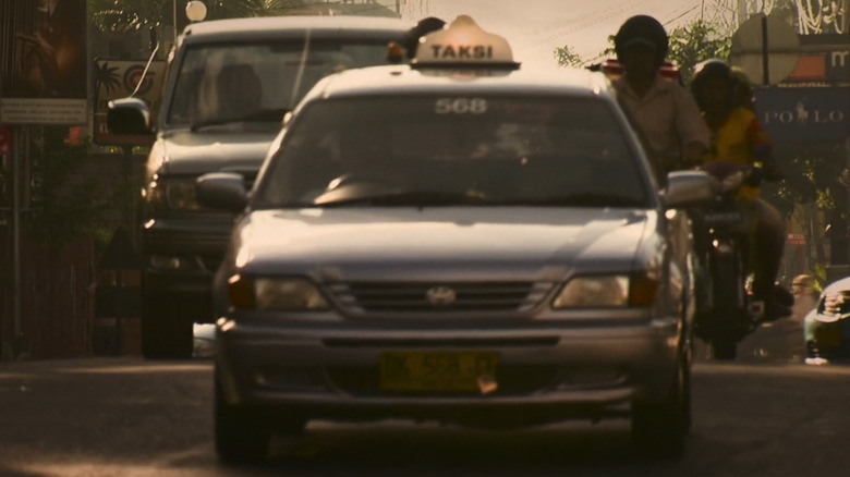 A silver Toyota Soluna taxi drives through Jakarta traffic in the "The Last of Us."