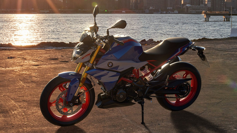 Blue and white BMW G 310 R parked in front of water