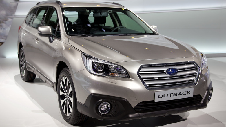 A 2015 Subaru Outback EU Version presented indoors at a show in grey metallic finish