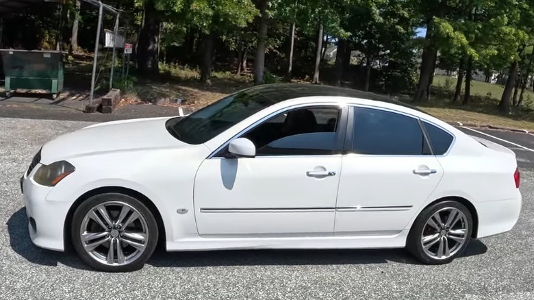 Side view of a white Infiniti M45 with front window down
