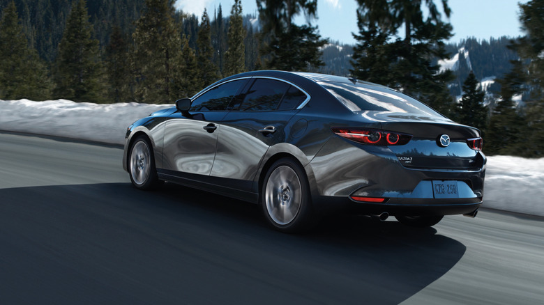 Rear 3/4 action shot of a gray 2020 Mazda 3 sedan.