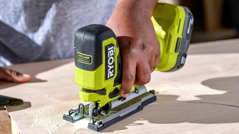 person using jig saw on wood