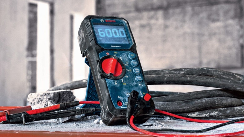 A multimeter placed at a construction site under rough jobsite conditions.