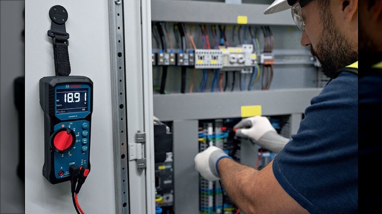 Electrician uing a multimeter to get electrical readings.