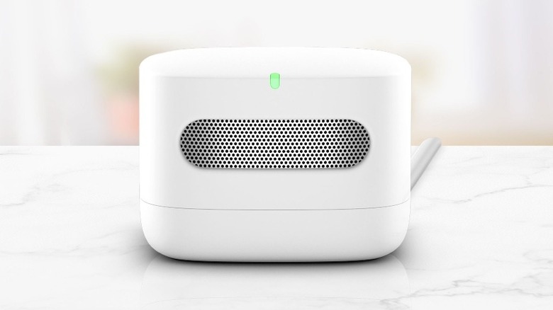 Amazon air quality monitor on granite counter next to other items