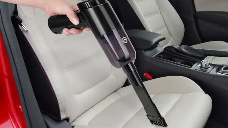 Kobot portable cordless vacuum cleaner cleaning a car seat