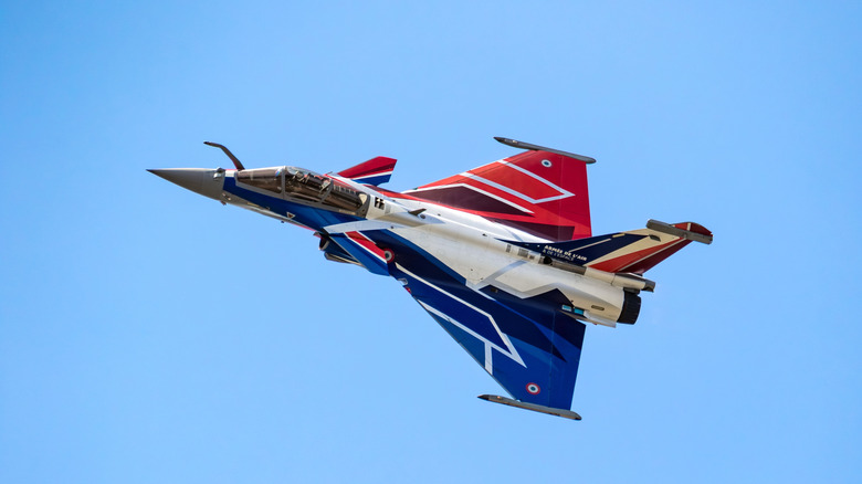 A Dassault Rafale Fighter Jet painted with the colors of the French Flag at a display.