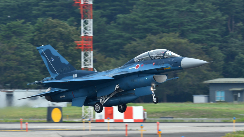 A mitsubishi F-2 B variant multirole fighter jet taking off left to right.
