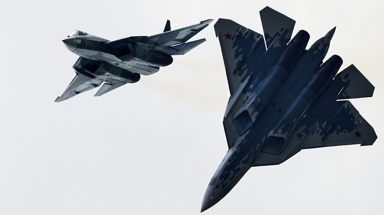 Two russian SU-57 felons conducting aerial maneuvers, photographed from below