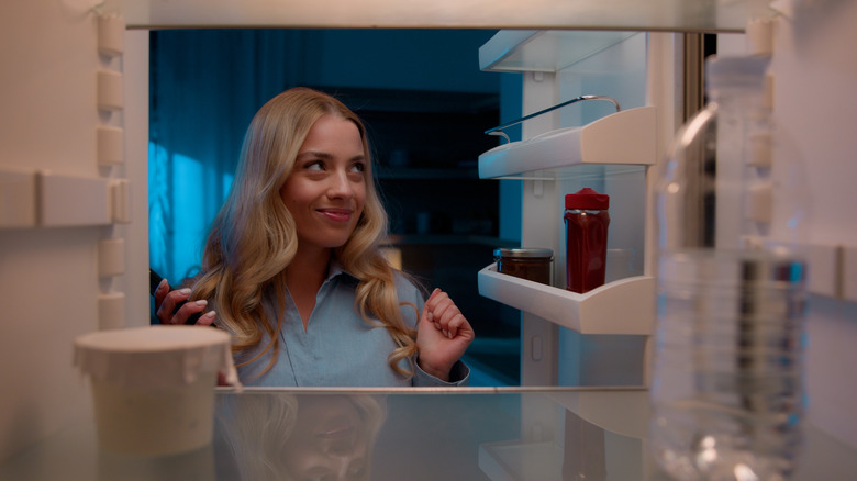 Woman looking in fridge for late night snack