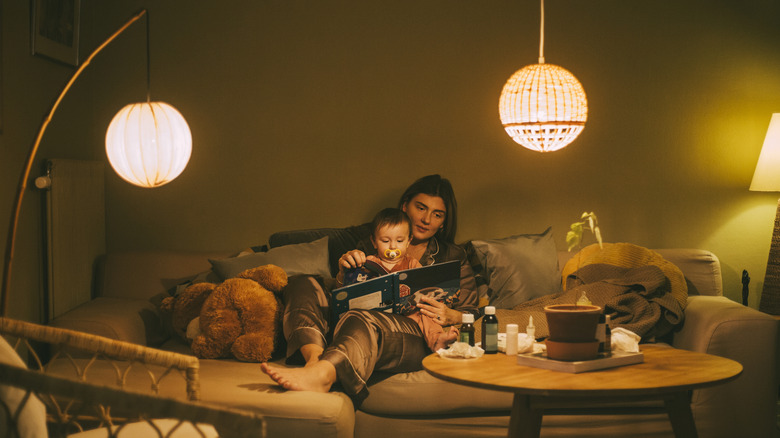 Mother and daughter reading with overhanging lights