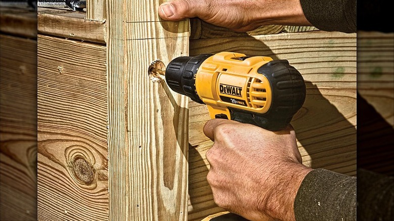 Drilling through wood with a DeWalt drill driver.