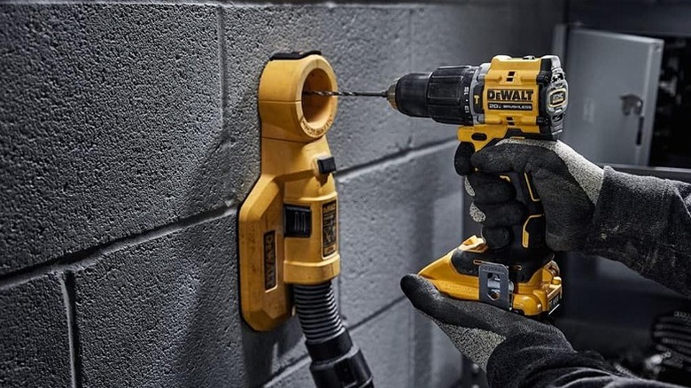Using a hammer drill on a concrete wall.