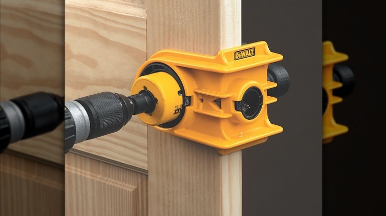 Using a door lock installation kit on a wooden door.