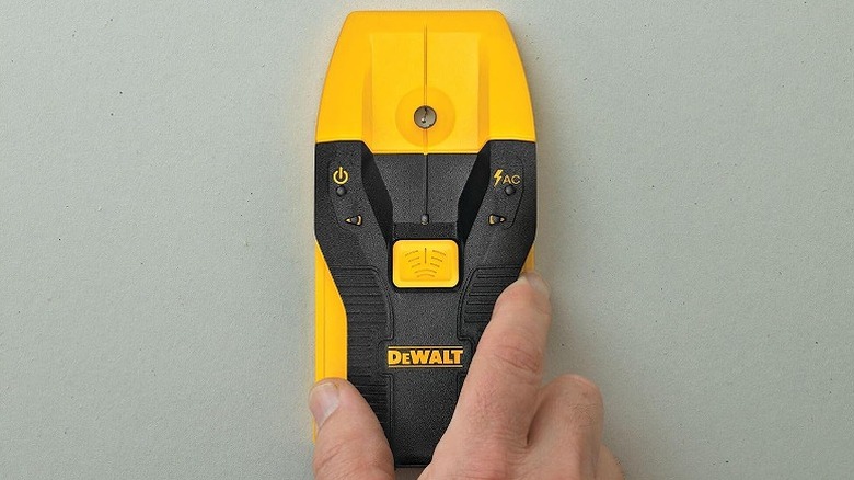 Using a stud finder on a wall.