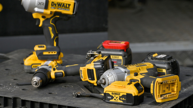 Multiple DeWalt tools placed on a table.