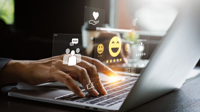 Holographic images of happy user reviews above a laptop.