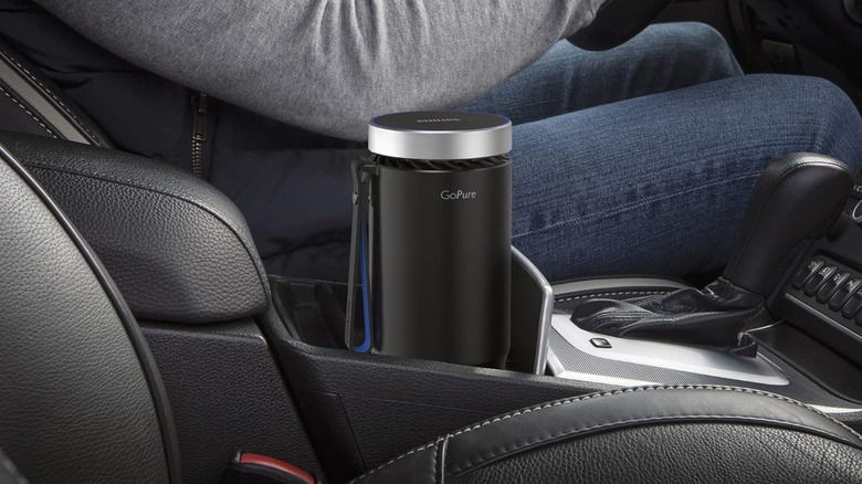 A Philips car air purifier placed inside a cup holder