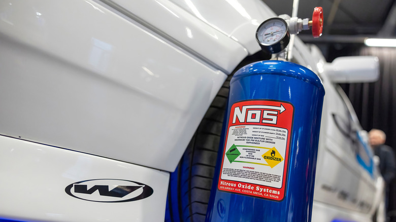 A canister of Nitrous oxide stood next to a sports car